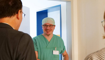 Eine OP-Pflegekraft in grüner Funktionskleidung und Kopfhaube unterhält sich auf dem Flur mit einem Mitarbeiter am Internationalen Tag der Pflegenden im Evangelischen Amalie Sieveking Krankenhaus in Hamburg. Eine OP-Pflegekraft in grüner Funktionskleidung und Kopfhaube unterhält sich auf dem Flur mit einem Mitarbeiter am Internationalen Tag der Pflegenden im Evangelischen Amalie Sieveking Krankenhaus in Hamburg.
